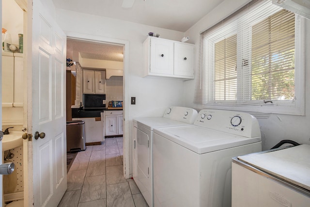 clothes washing area with ceiling fan, cabinets, and independent washer and dryer