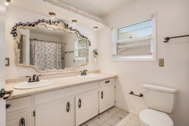 bathroom with walk in shower, vanity, and toilet