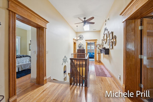 hall with a notable chandelier and light hardwood / wood-style floors