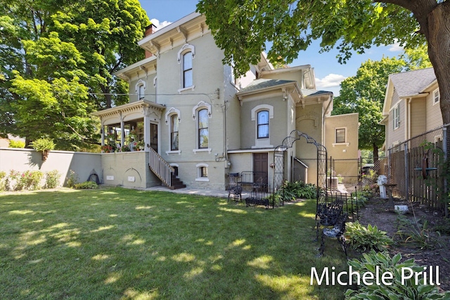 rear view of property featuring a lawn