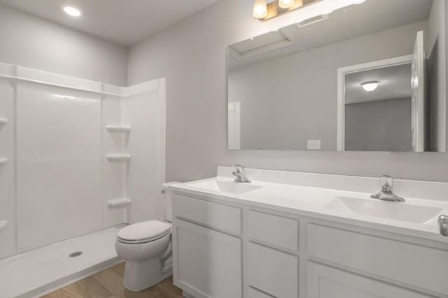 bathroom featuring hardwood / wood-style floors, vanity, toilet, and walk in shower