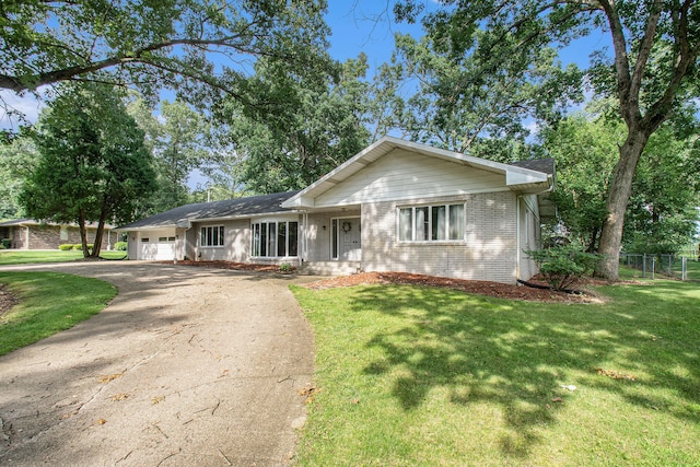 ranch-style house featuring a garage and a front yard