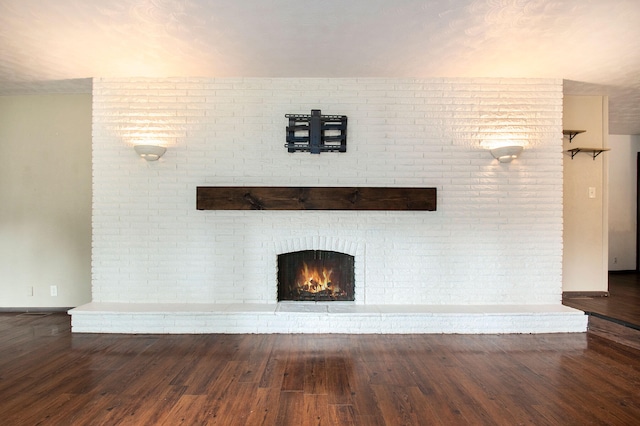 unfurnished living room with hardwood / wood-style floors and a brick fireplace