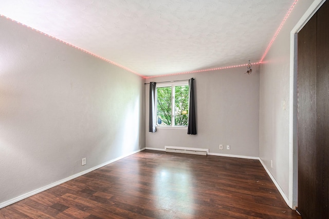 spare room with a chandelier, dark hardwood / wood-style flooring, crown molding, and a baseboard radiator