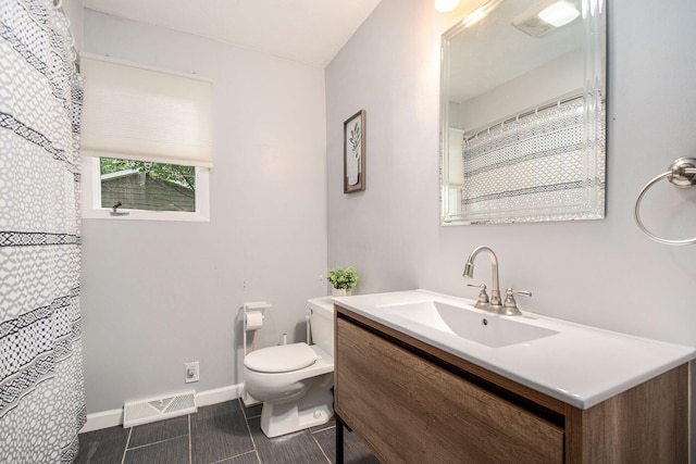 bathroom with tile patterned flooring, vanity, and toilet