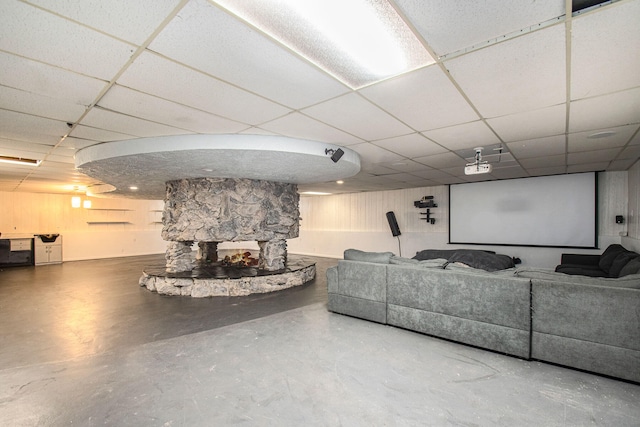 home theater featuring concrete flooring and a paneled ceiling