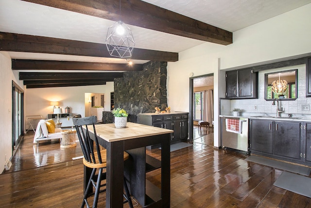 dining space with vaulted ceiling with beams, sink, and dark wood-type flooring