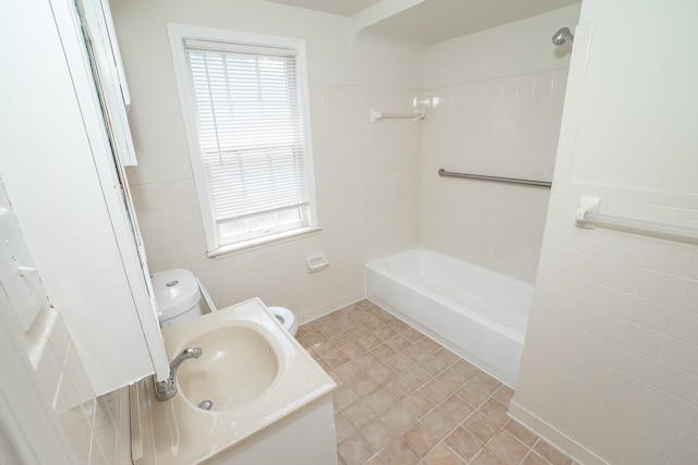 full bathroom with sink, tile walls, tile patterned flooring, toilet, and tiled shower / bath