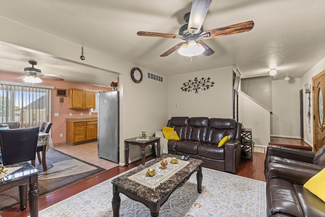 living room featuring a textured ceiling and light hardwood / wood-style floors