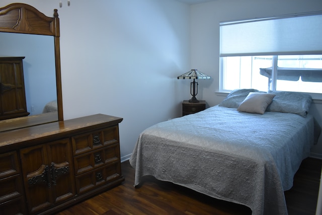 bedroom with dark wood-type flooring