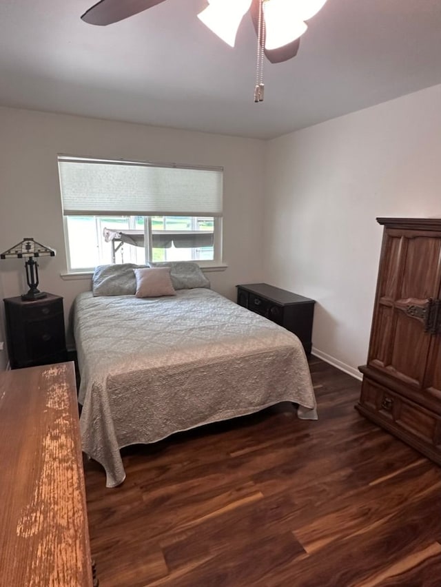 bedroom with dark hardwood / wood-style floors and ceiling fan