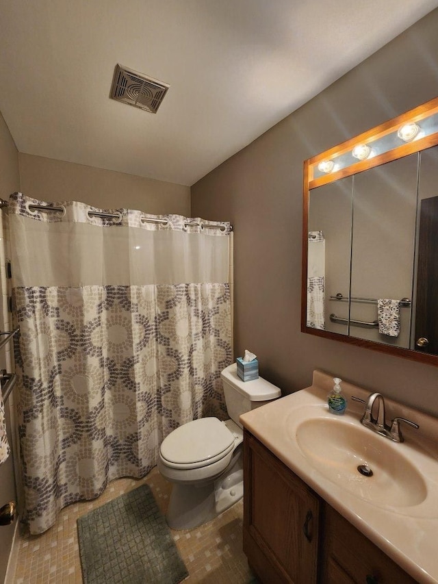 bathroom featuring vanity, walk in shower, and toilet