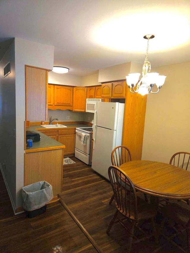 kitchen featuring sink, hanging light fixtures, dark hardwood / wood-style floors, a notable chandelier, and white appliances