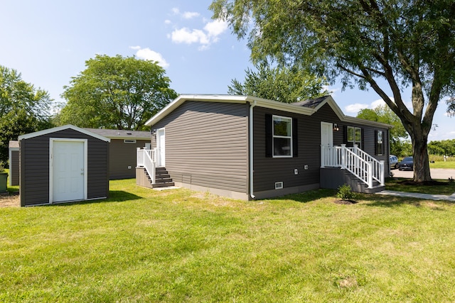 rear view of house featuring a storage shed and a lawn