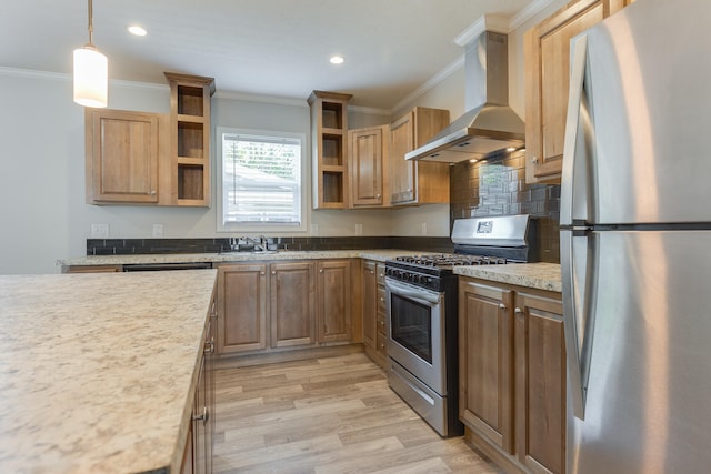 kitchen featuring crown molding, wall chimney exhaust hood, decorative light fixtures, and appliances with stainless steel finishes