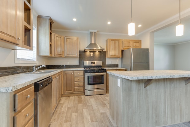 kitchen featuring hanging light fixtures, wall chimney exhaust hood, stainless steel appliances, and light hardwood / wood-style floors