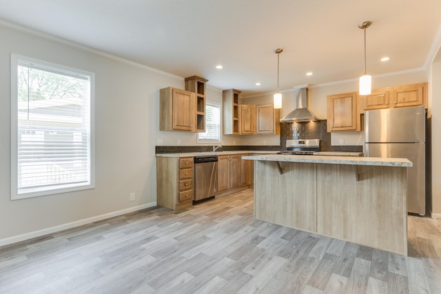 kitchen with wall chimney exhaust hood, a breakfast bar, stainless steel appliances, light hardwood / wood-style floors, and a kitchen island