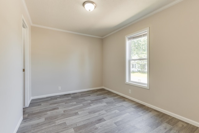 spare room featuring crown molding and light wood-type flooring