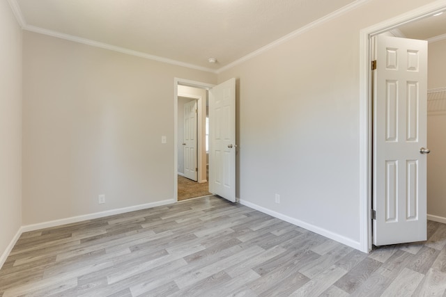 unfurnished room with light wood-type flooring and ornamental molding