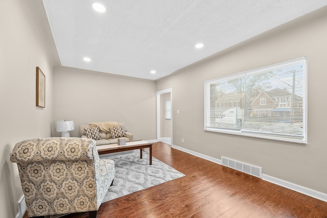 sitting room featuring hardwood / wood-style flooring and a textured ceiling