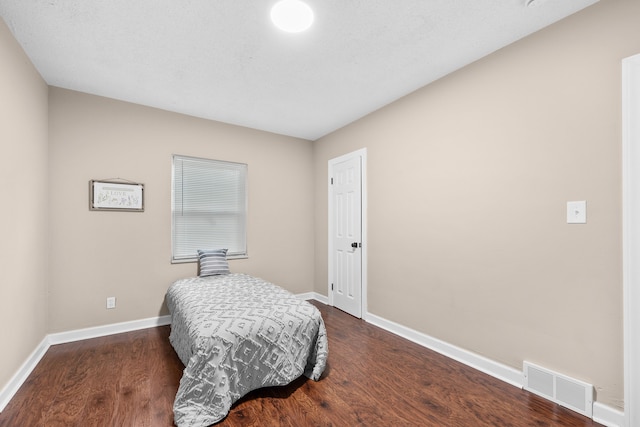 bedroom with dark hardwood / wood-style floors