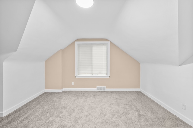 additional living space with light colored carpet and lofted ceiling