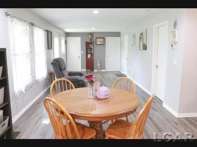 dining space with wood-type flooring