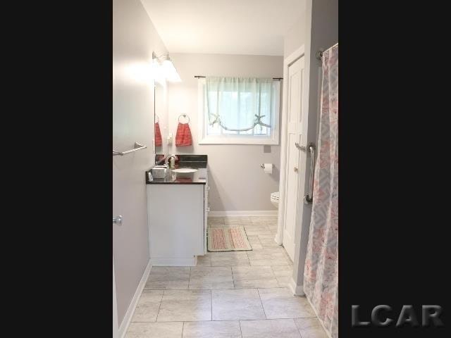 bathroom featuring tile patterned floors, vanity, and toilet