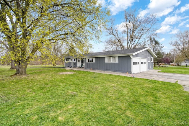 ranch-style home with board and batten siding, a front yard, a garage, and concrete driveway