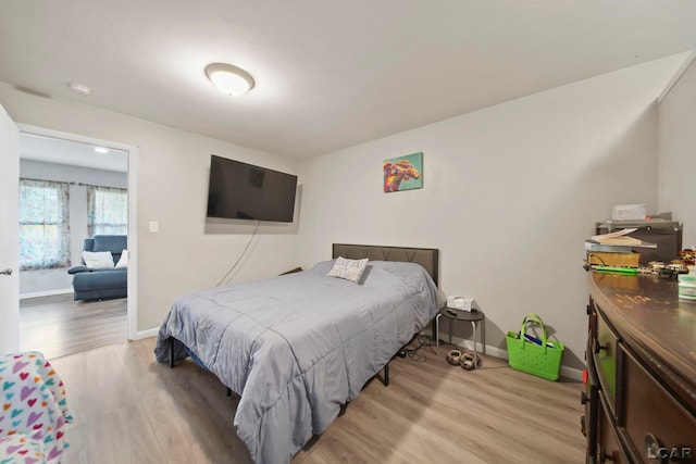 bedroom with baseboards and light wood-style flooring