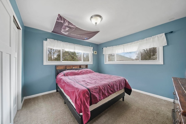 carpeted bedroom with baseboards and a closet