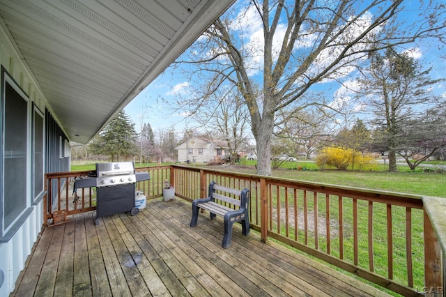wooden terrace with a lawn and a grill