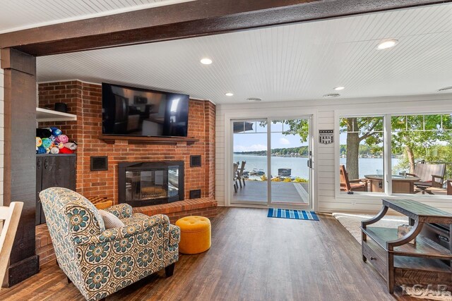 living room with hardwood / wood-style flooring and a brick fireplace