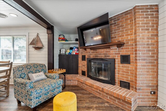 living room featuring wood walls, a fireplace, and wood-type flooring