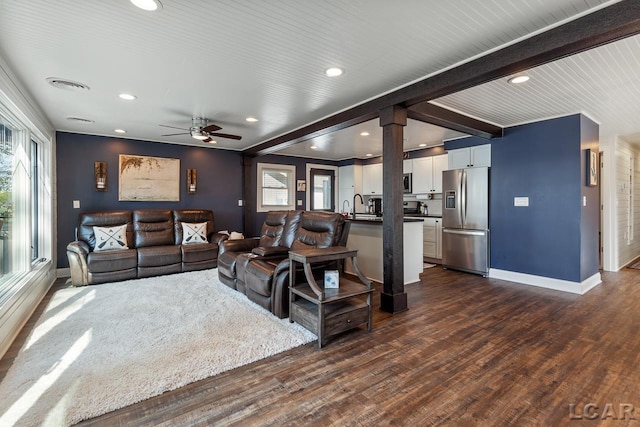 living room with beam ceiling, ceiling fan, dark wood-type flooring, and sink