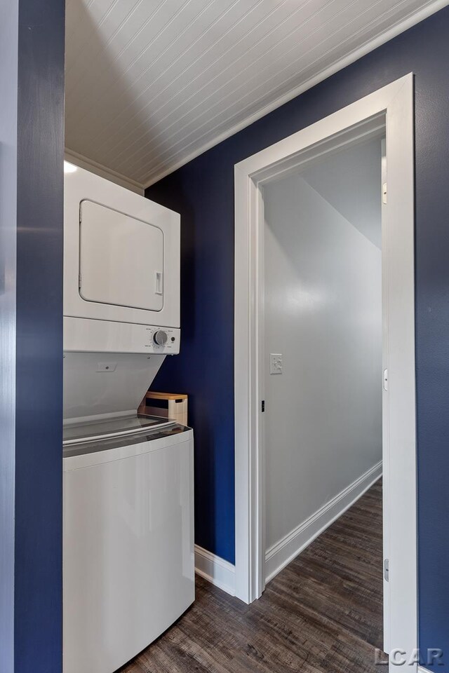 clothes washing area with dark hardwood / wood-style flooring and stacked washing maching and dryer