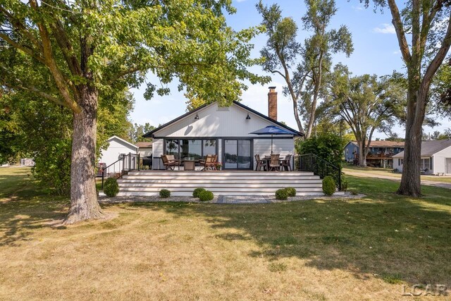 back of house featuring a deck and a yard