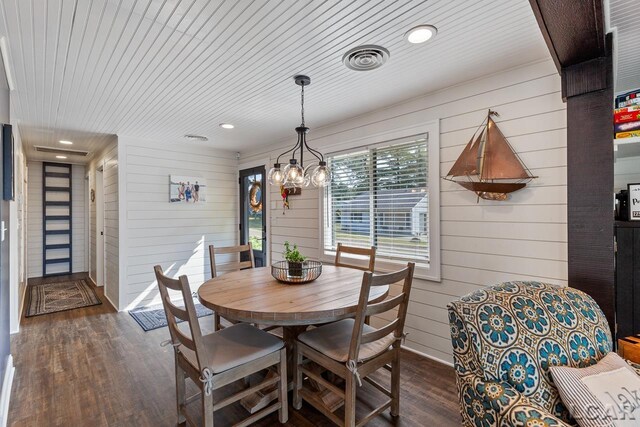 dining space featuring wood walls, dark hardwood / wood-style flooring, and wooden ceiling