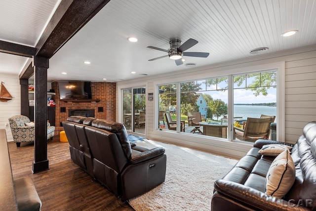 living room featuring dark hardwood / wood-style floors, a wealth of natural light, wood walls, and ceiling fan