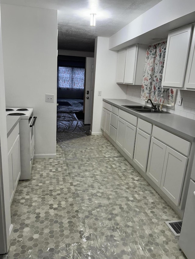 13664 Wabasis Ave NE, Cedar Springs, MI 49319 - kitchen featuring white electric stove, a sink, decorative backsplash, and white cabinetry
