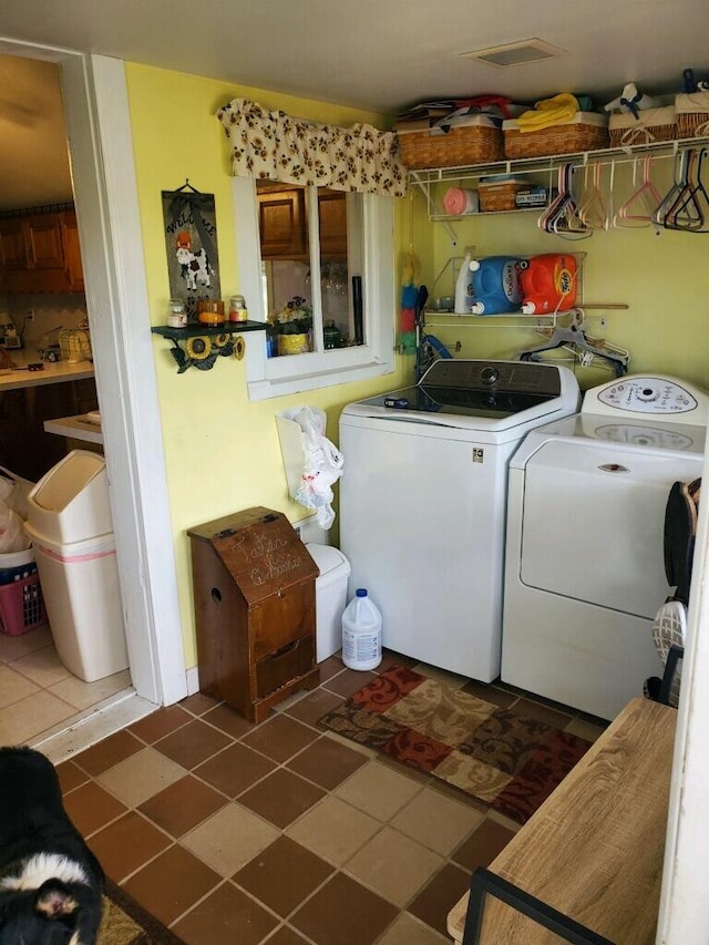 laundry room featuring dark tile patterned floors and separate washer and dryer