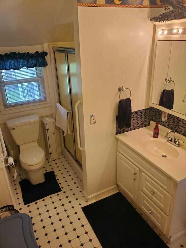 bathroom featuring tile patterned floors, vanity, toilet, and a shower with shower door