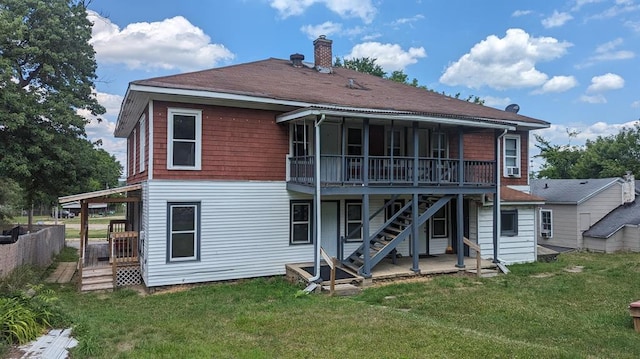 rear view of house featuring a lawn, a deck, and a patio