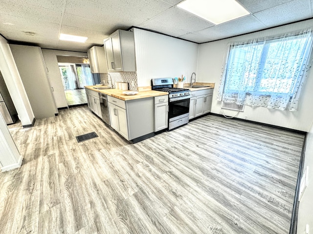 kitchen featuring butcher block counters, plenty of natural light, stainless steel appliances, and light hardwood / wood-style flooring