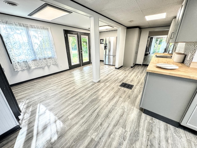 interior space with wooden counters, stainless steel fridge with ice dispenser, gray cabinets, and light hardwood / wood-style floors