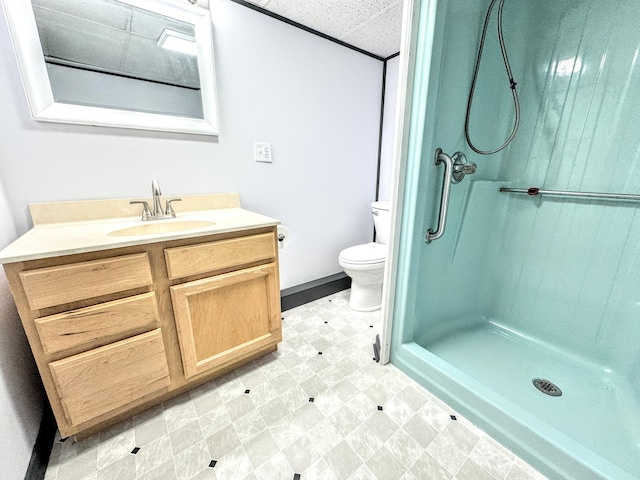 bathroom featuring a paneled ceiling, vanity, toilet, and walk in shower