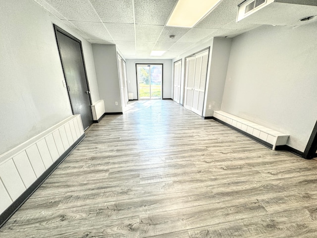 hallway featuring a paneled ceiling and light hardwood / wood-style flooring