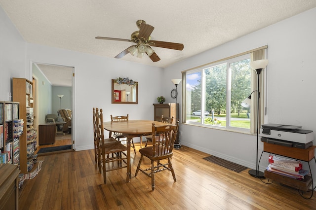 dining room featuring a textured ceiling, hardwood / wood-style flooring, and ceiling fan