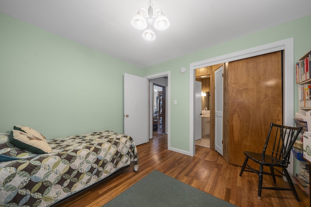 bedroom with a chandelier, dark wood-type flooring, and a closet