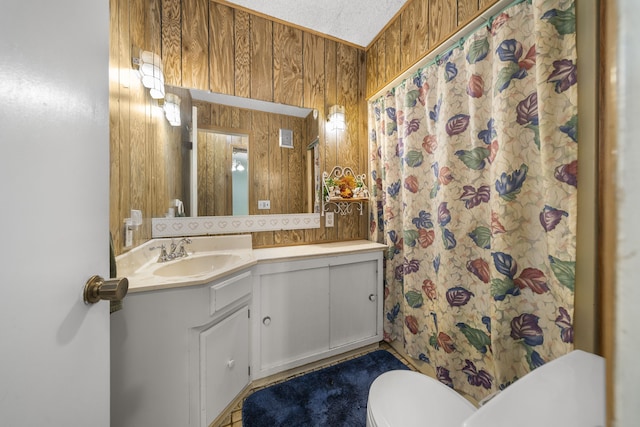 bathroom featuring vanity, toilet, and wood walls